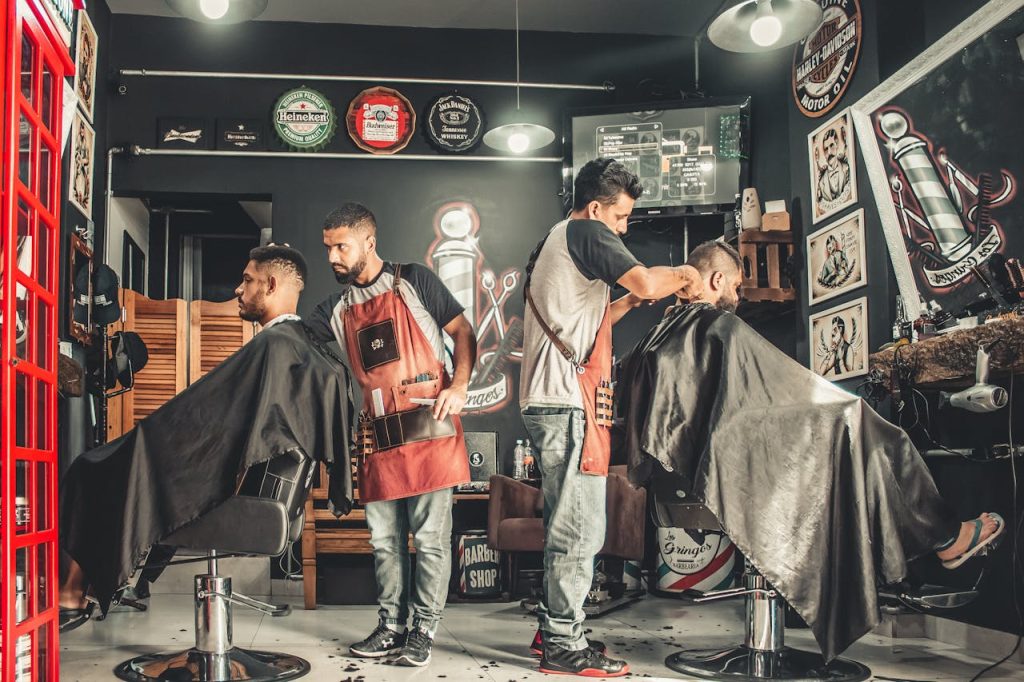 pexels photo 1813272 A bustling barbershop with two men getting haircuts, showcasing a vibrant barber environment.